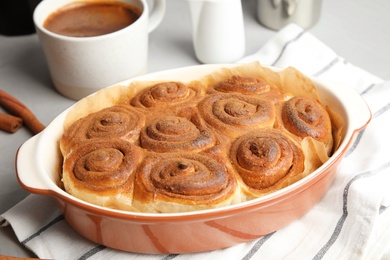 Baking dish with cinnamon rolls on table