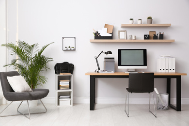 Photo of Modern computer on table in office interior. Stylish workplace