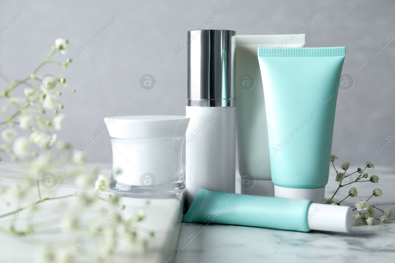 Photo of Set of luxury cosmetic products on white marble table