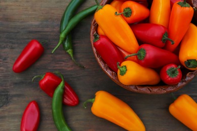 Different ripe bell peppers on wooden table, flat lay