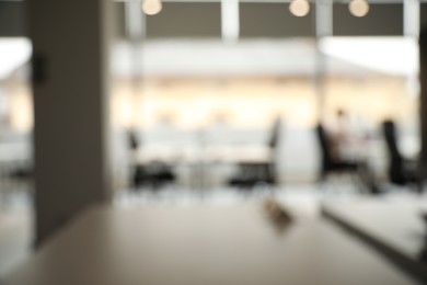 Photo of Blurred view of cozy workspaces with tables and chairs in office