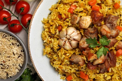 Delicious pilaf and products on table, flat lay