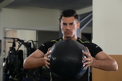 Photo of Athletic man with medicine ball in modern gym