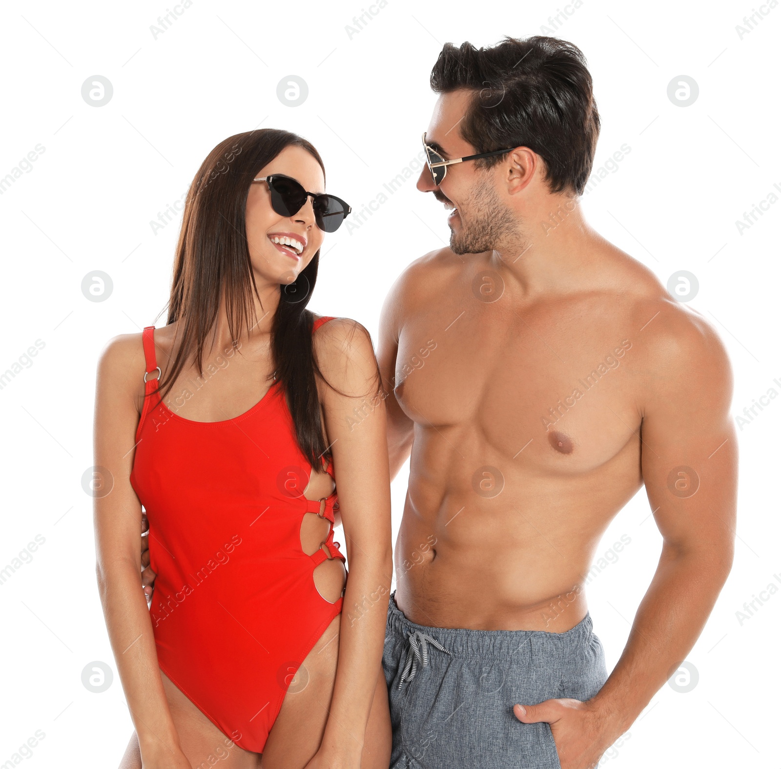 Photo of Young attractive couple in beachwear and sunglasses on white background