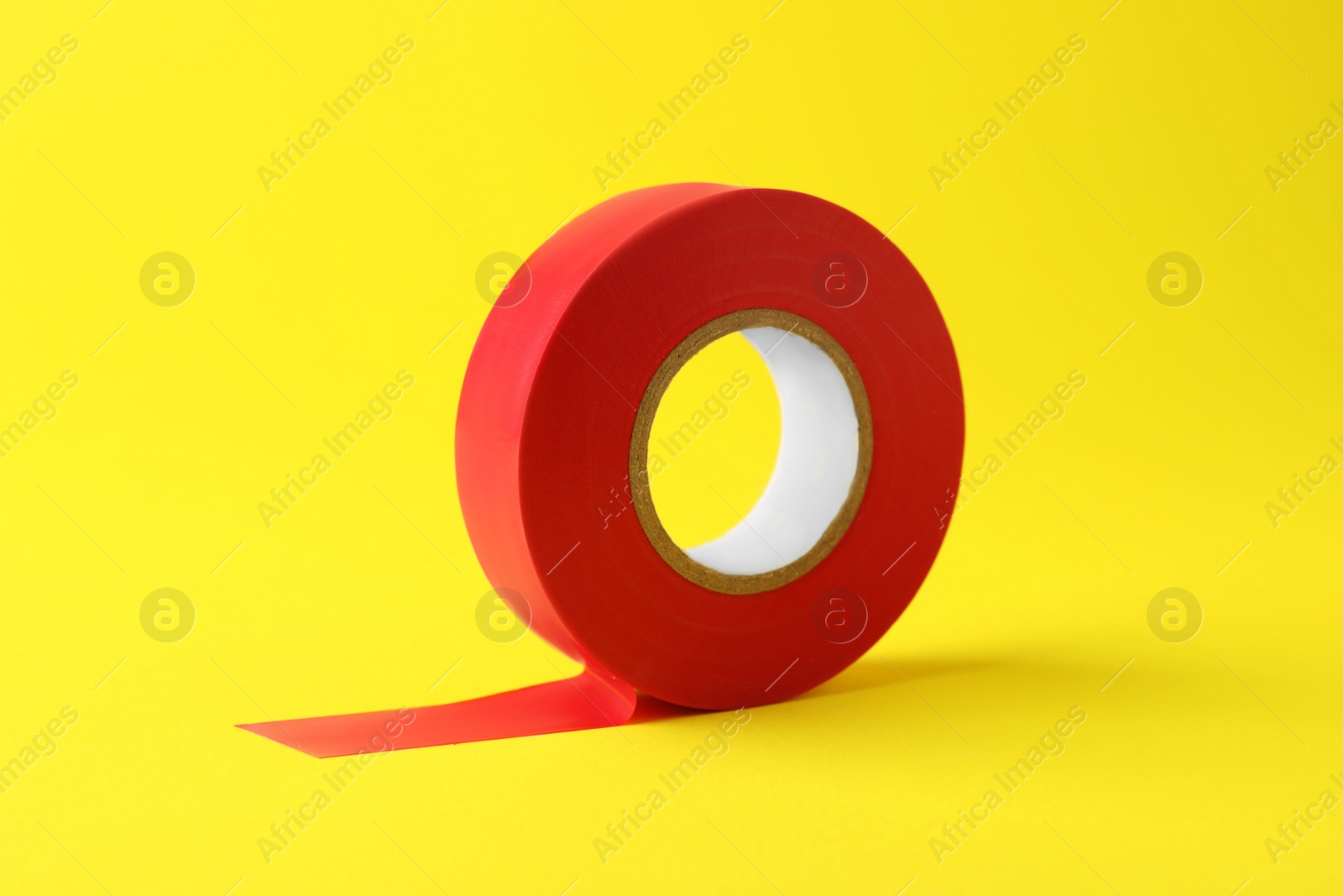 Photo of Red insulating tape on yellow background. Electrician's supply