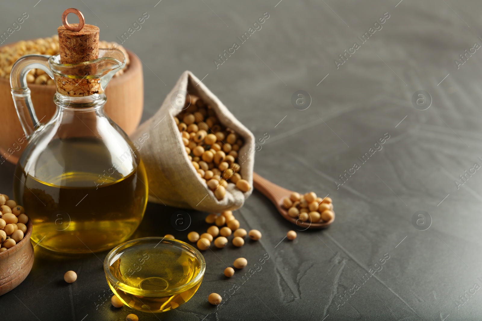 Photo of Composition with soybean oil on grey table, space for text