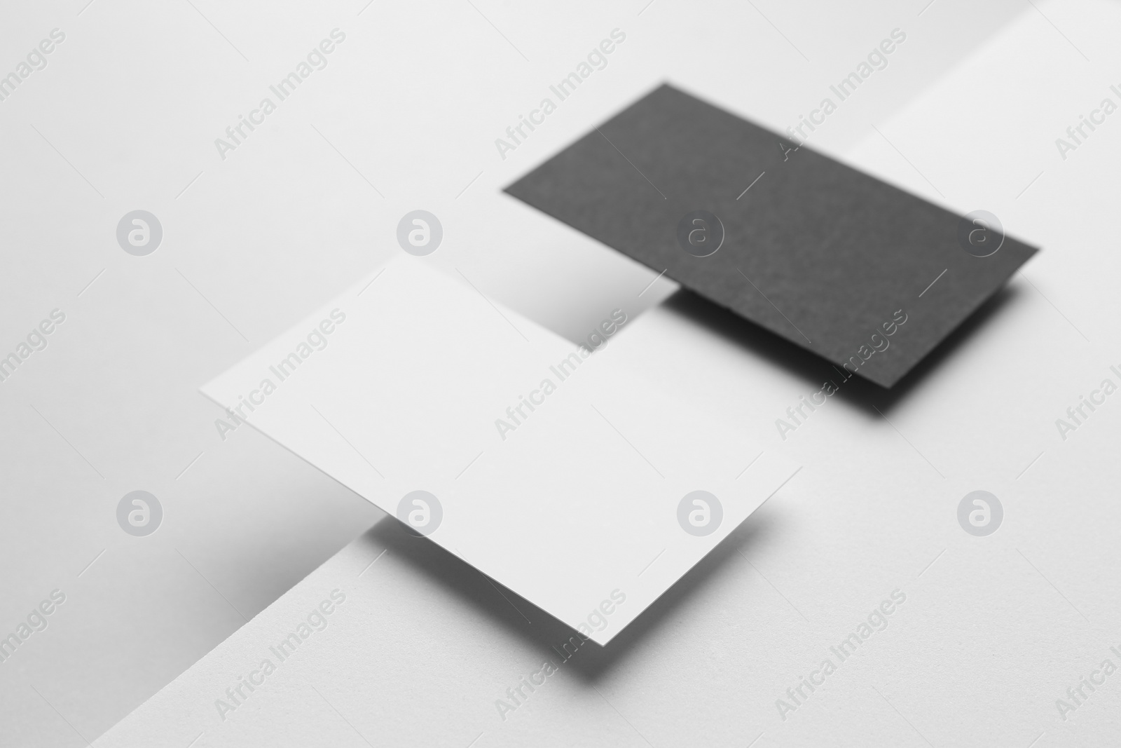 Photo of Blank black and white business cards on light background. Mockup for design