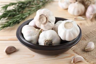 Photo of Bulbs and cloves of fresh garlic on wooden table, closeup