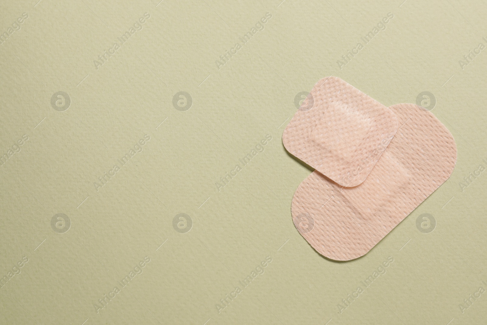 Photo of Different contraceptive patches on green background, flat lay. Space for text