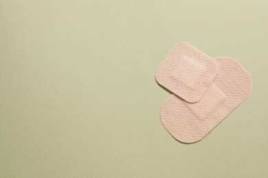 Photo of Different contraceptive patches on green background, flat lay. Space for text