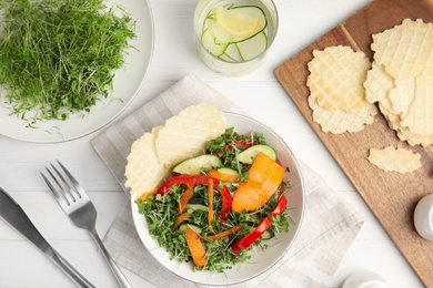 Delicious vegetable salad with microgreen served on white wooden table, flat lay