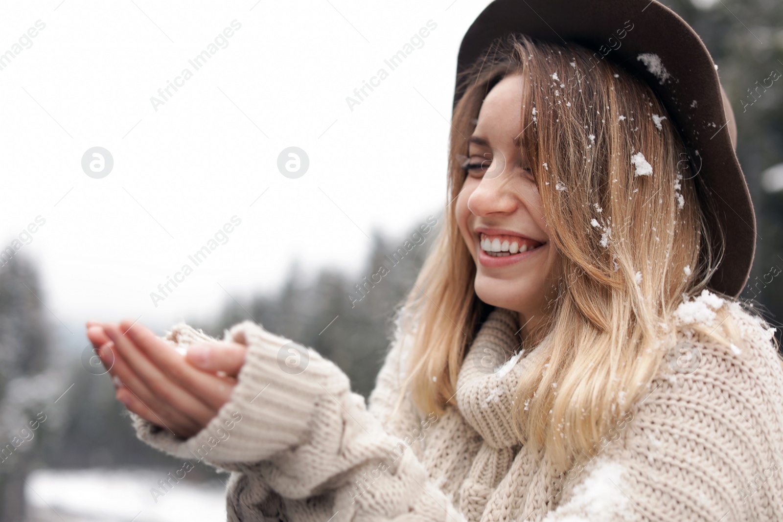 Photo of Young woman playing with snow outdoors. Winter vacation