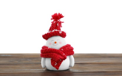 Photo of Cute decorative snowman in red hat and scarf on wooden table against white background