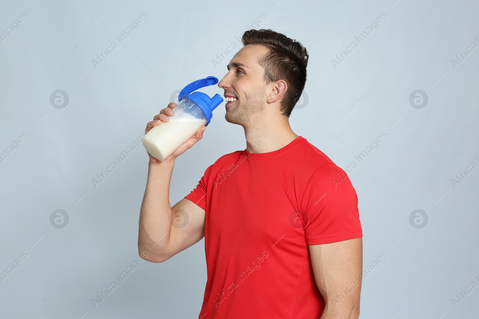 Photo of Portrait of man drinking protein shake on color background