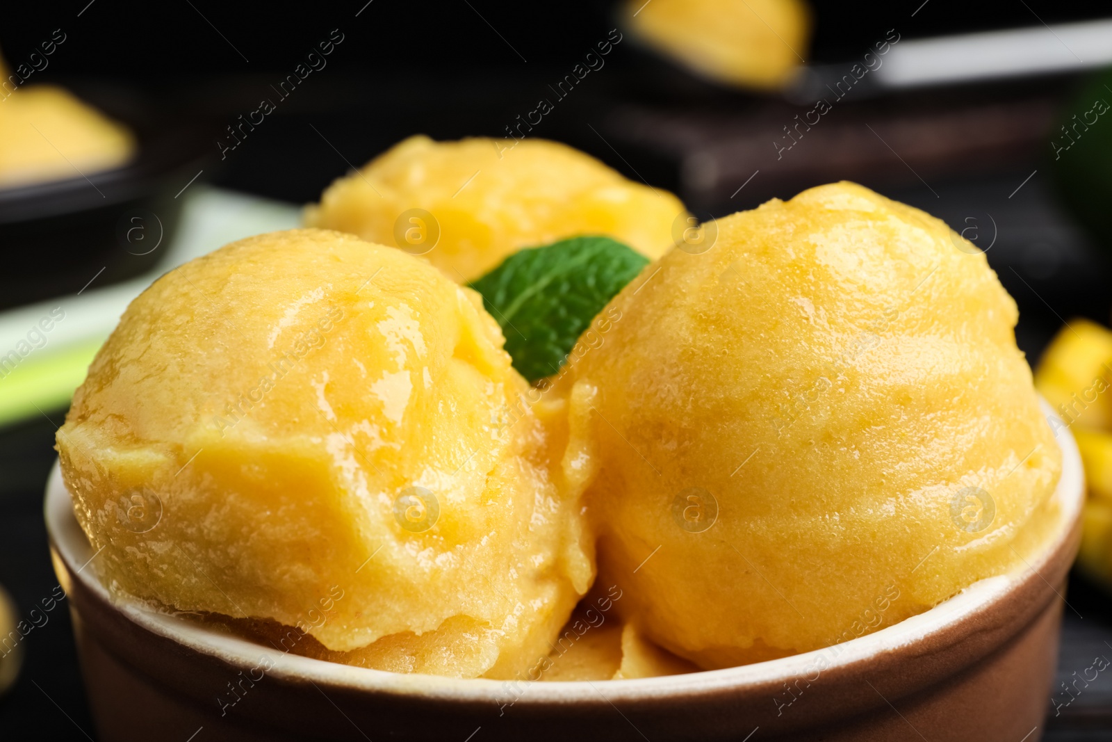 Photo of Yummy yellow ice cream in bowl, closeup