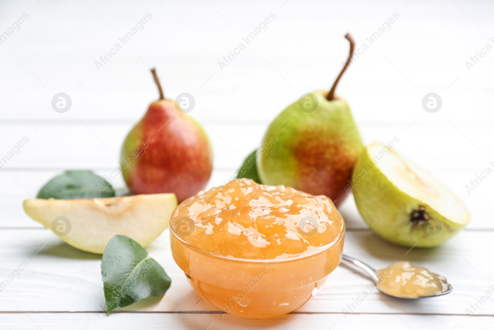 Photo of Delicious pear jam and fresh fruits on white wooden table