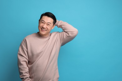Photo of Portrait of happy man on light blue background. Space for text