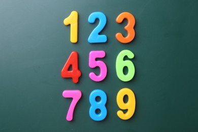 Colorful numbers on green background, flat lay