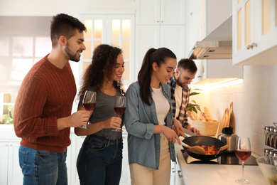 Happy people cooking food together in kitchen