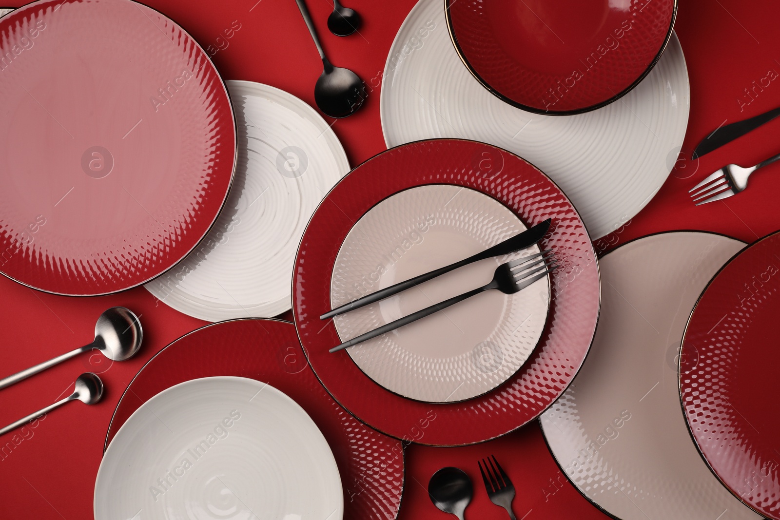 Photo of Stylish table setting with cutlery on red background, flat lay