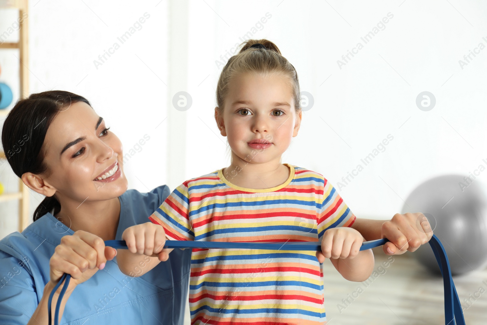 Photo of Orthopedist working with little girl in hospital gym