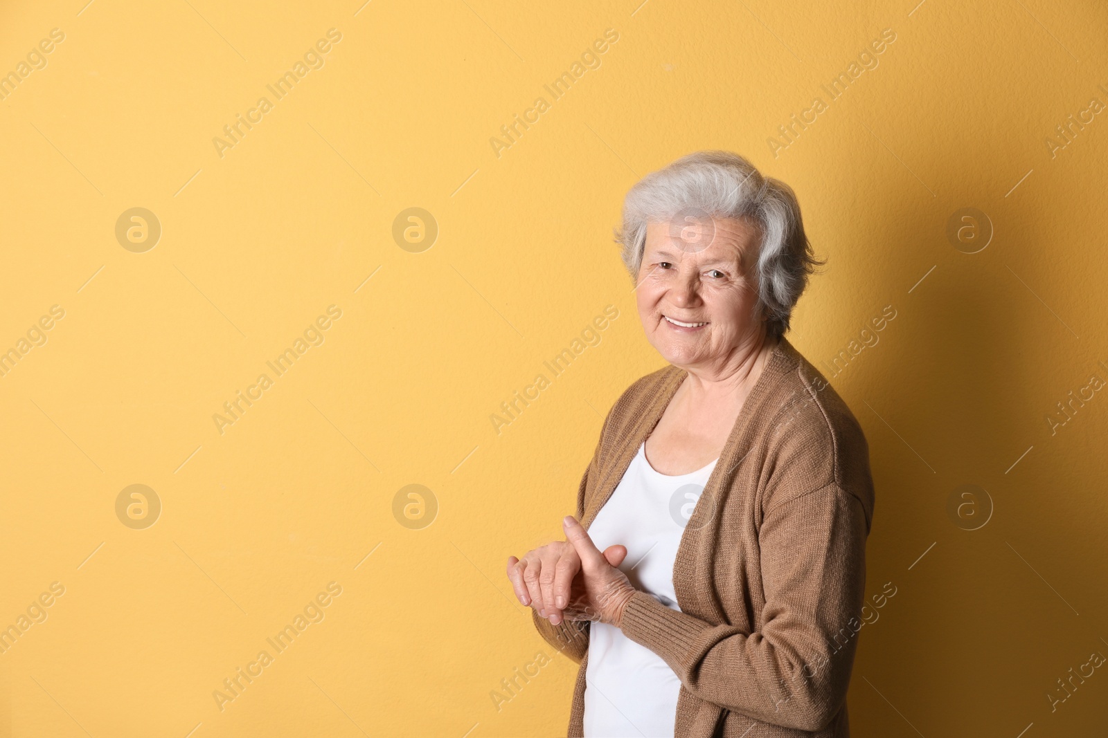 Photo of Portrait of grandmother in stylish clothes on color background, space for text