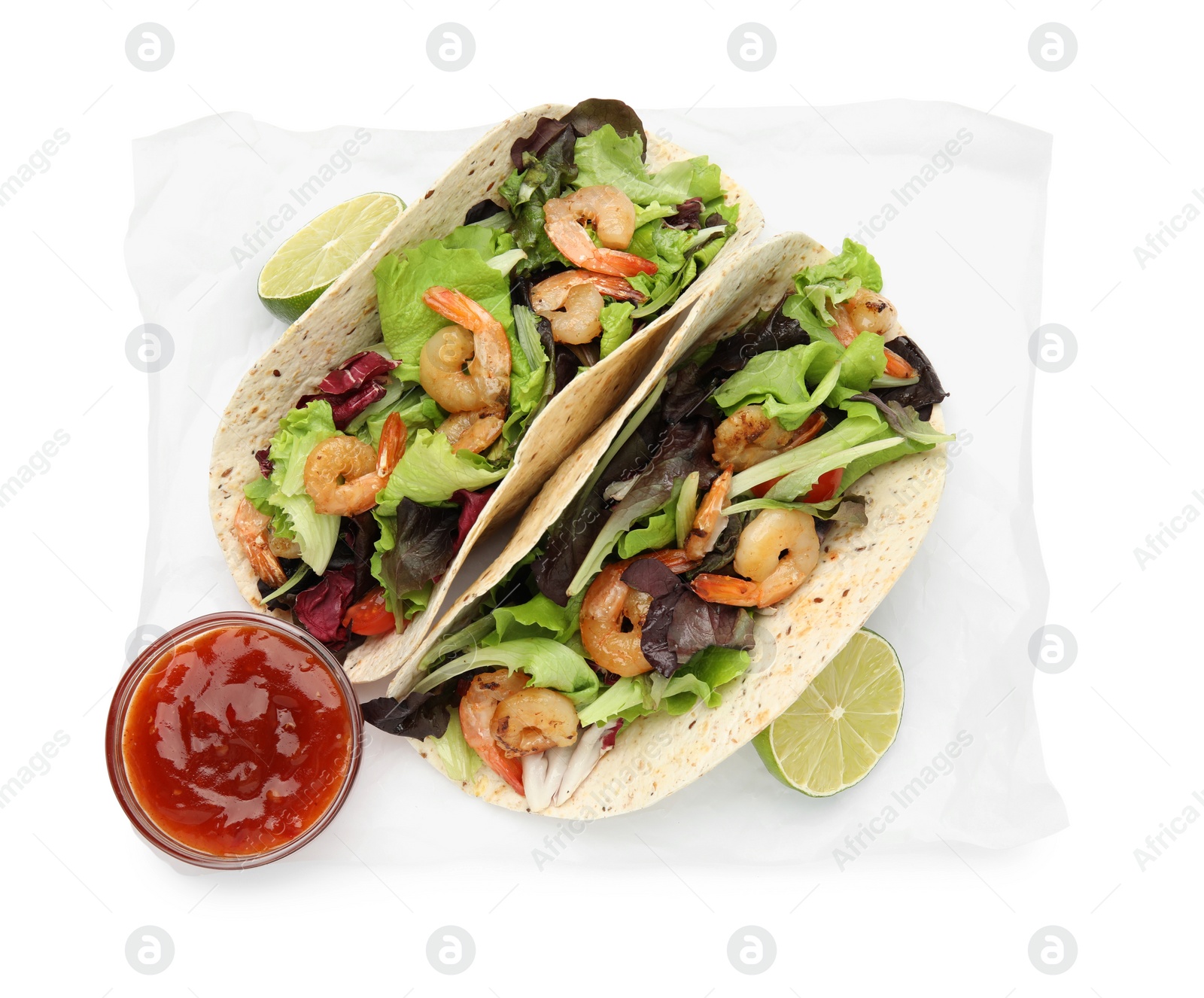 Photo of Delicious tacos with shrimps, lime and sauce on white background, top view