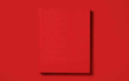 Photo of Hardcover book on red background, top view. Space for text