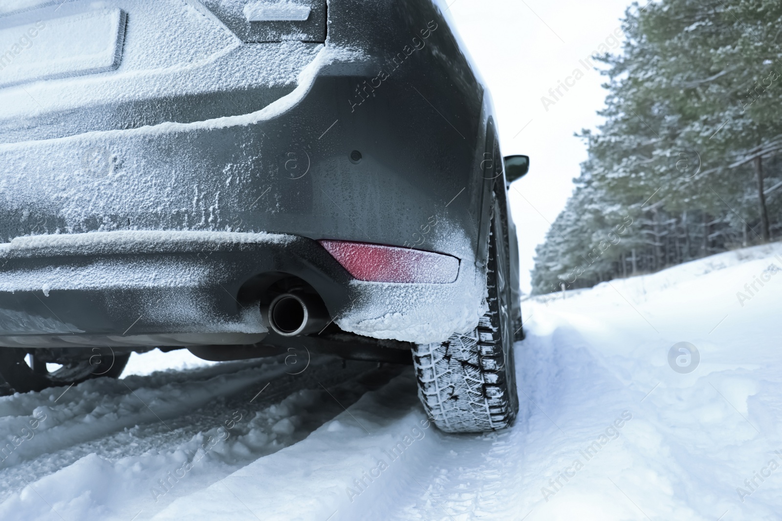 Photo of Snowy country road with car on winter day, closeup