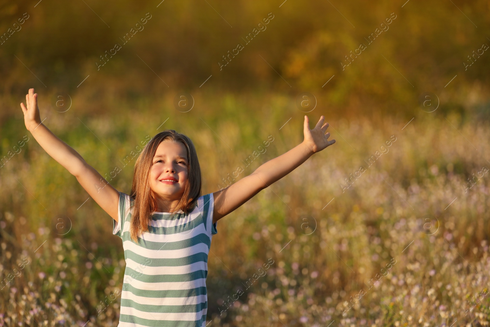 Photo of Cute little girl outdoors on sunny day. Child spending time in nature