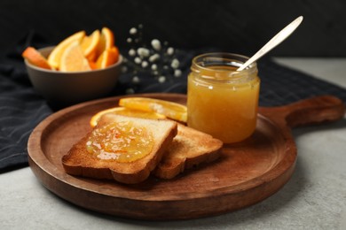 Photo of Delicious toasts with orange marmalade on light grey table