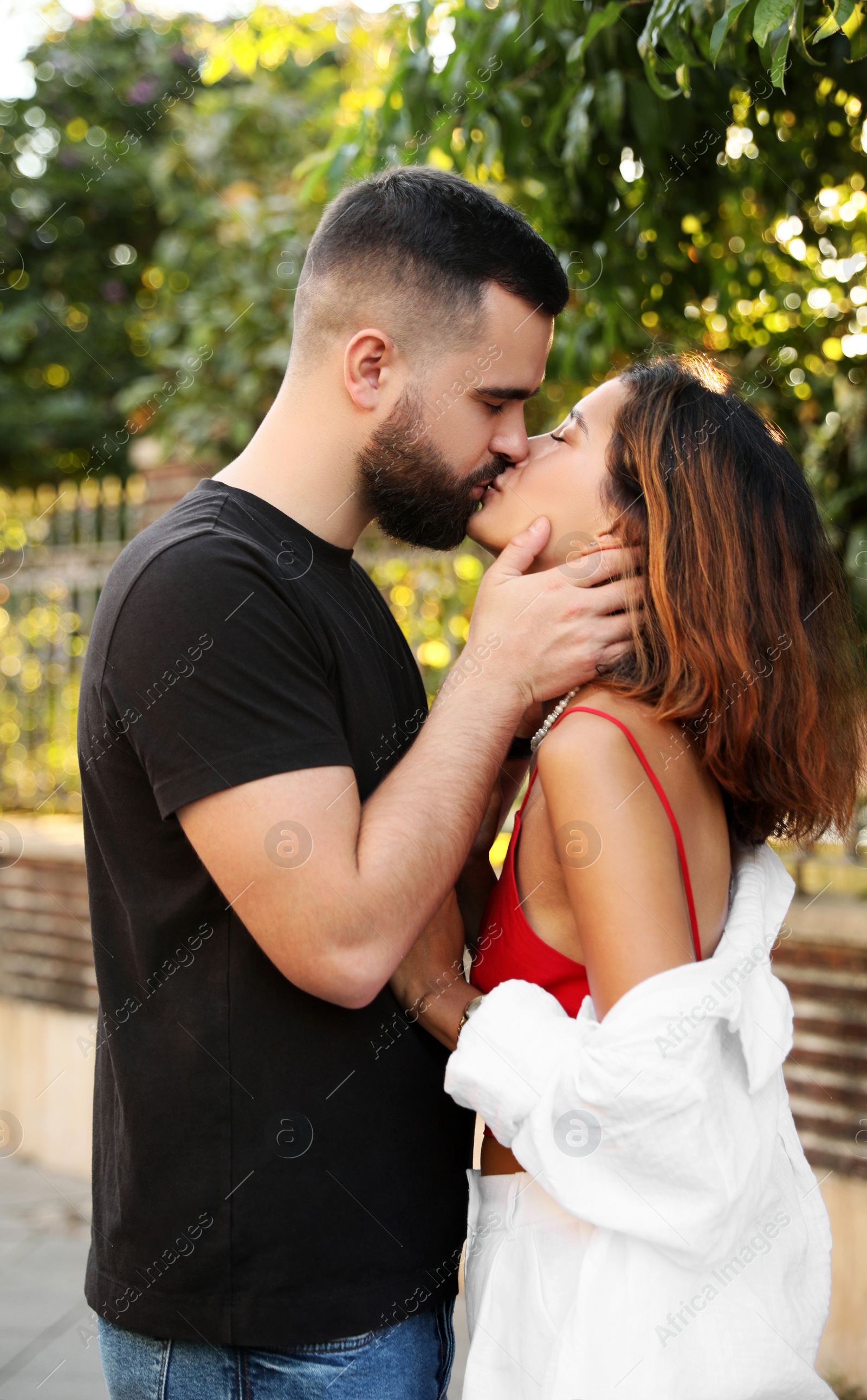 Photo of Happy young couple kissing on city street