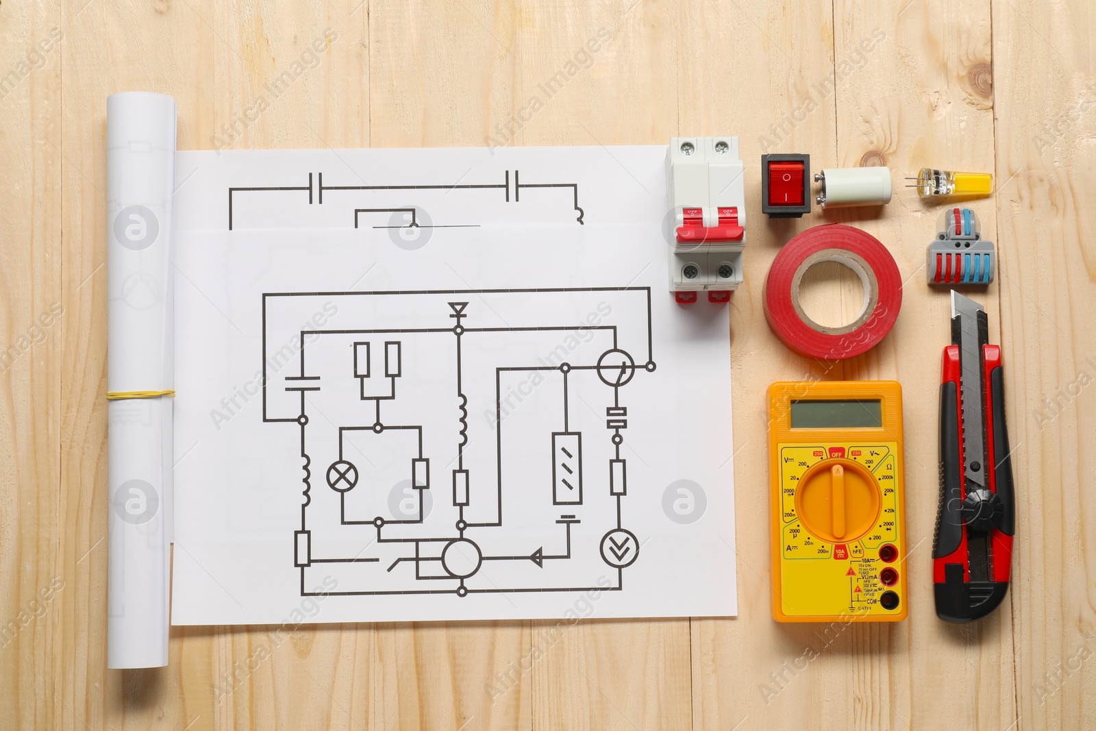 Photo of Flat lay composition with wiring diagrams and digital multimeter on wooden table