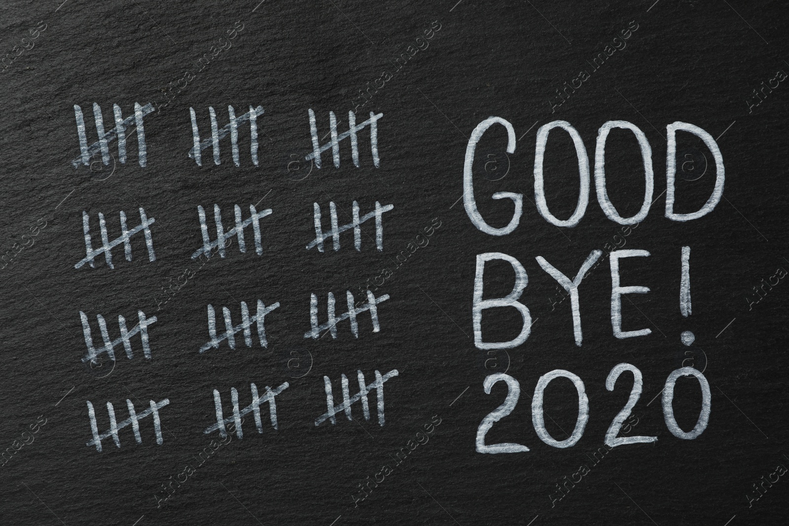 Photo of Crossed out sticks and text Goodbye 2020 on black chalkboard