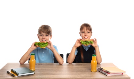 Photo of Happy children eating healthy food at school table on white background