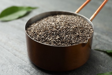 Photo of Saucepan with chia seeds on slate table, closeup