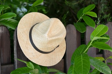 Photo of Stylish hat hanging on wooden fence. Beach accessory