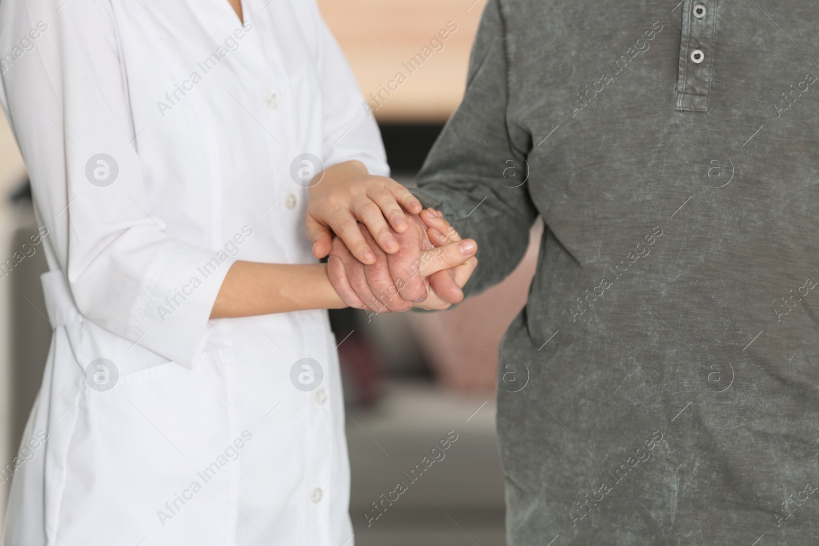 Photo of Elderly man with female caregiver on blurred background, closeup view