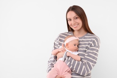 Photo of Happy mother with her cute baby on light background, space for text