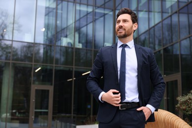 Photo of Happy real estate agent in suit outdoors. Space for text