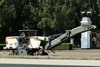 Cold milling machine on city street. Road repair service