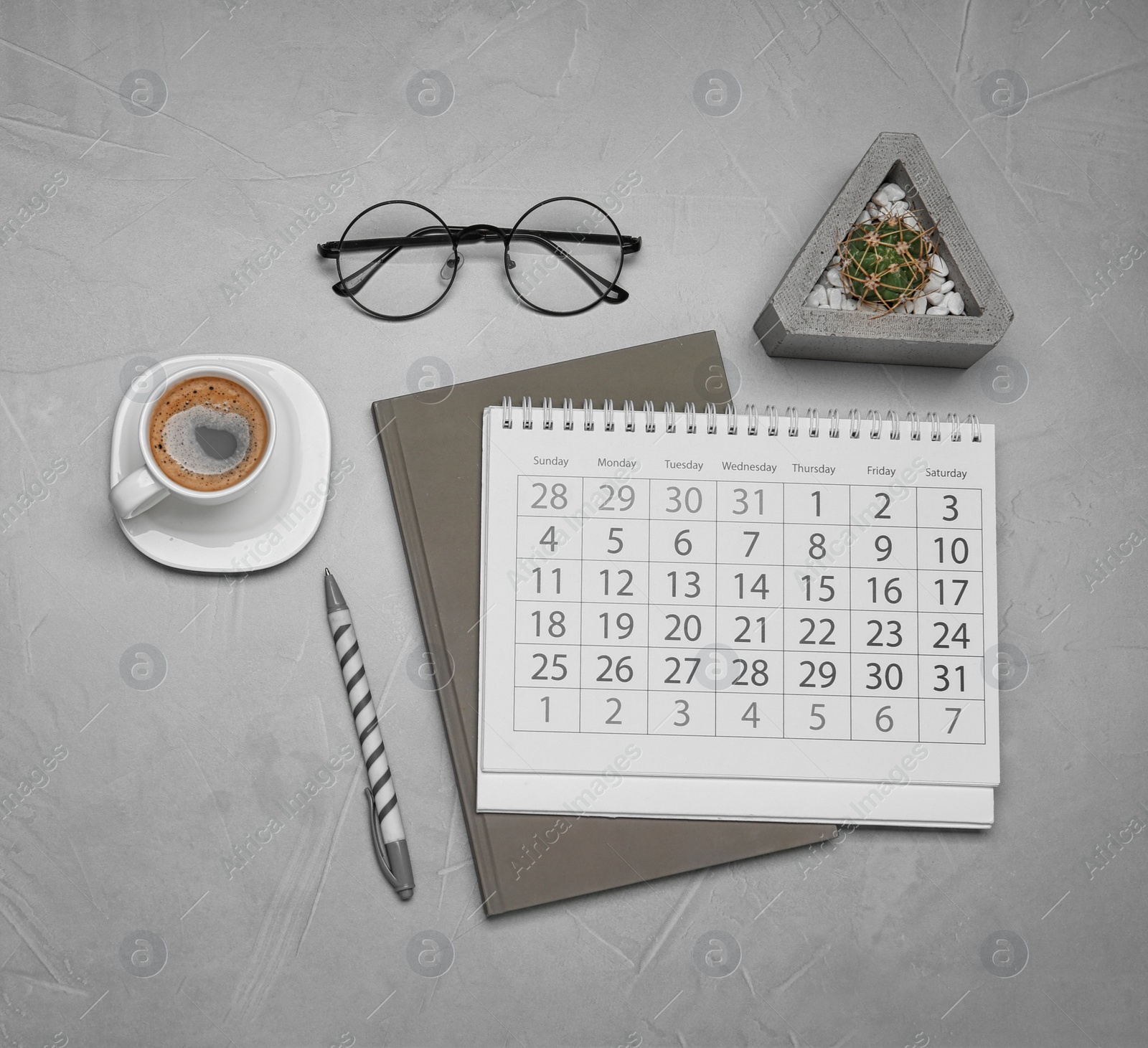 Photo of Flat lay composition with calendar and cup of coffee on grey table