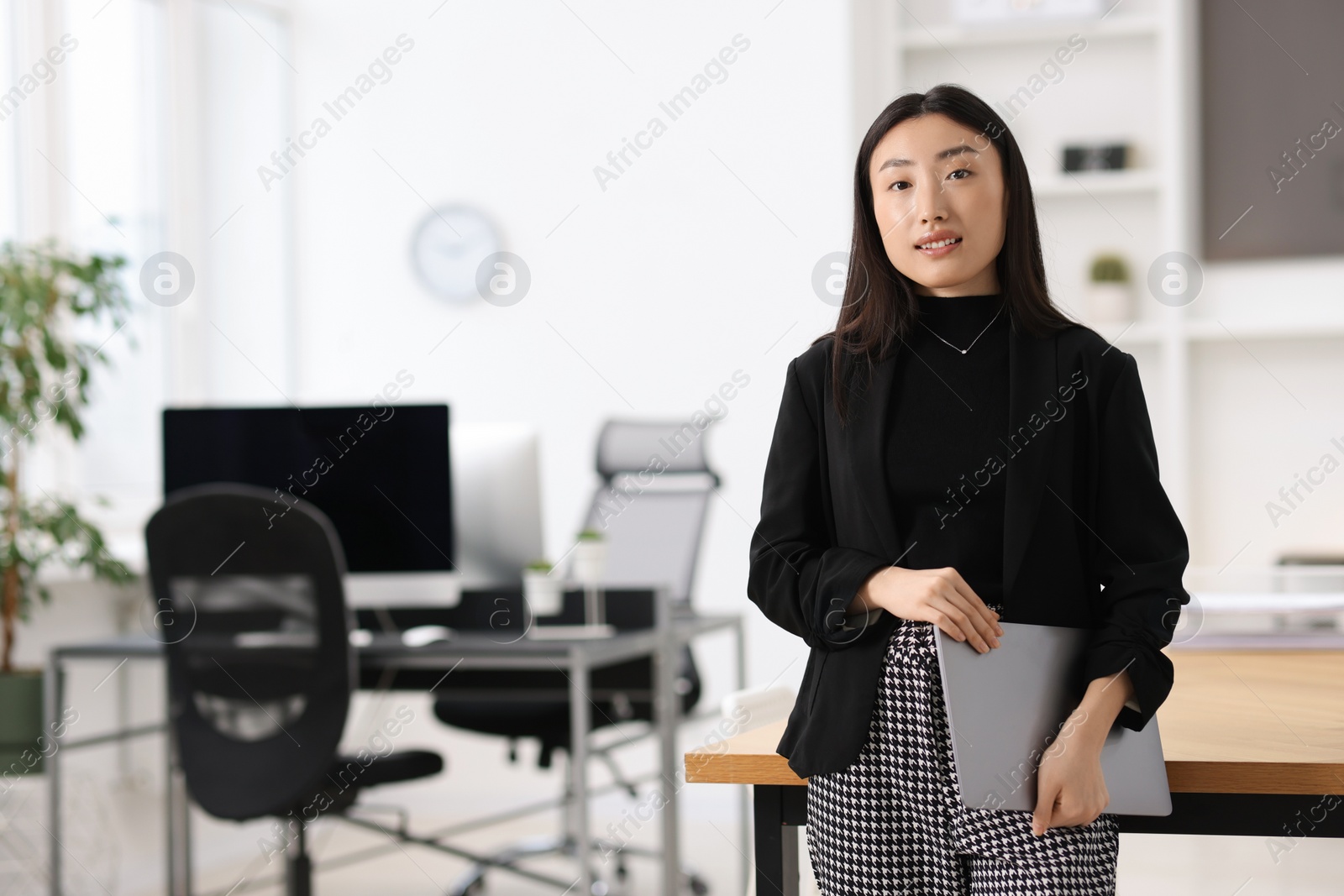 Photo of Portrait of smiling businesswoman with laptop in office. Space for text
