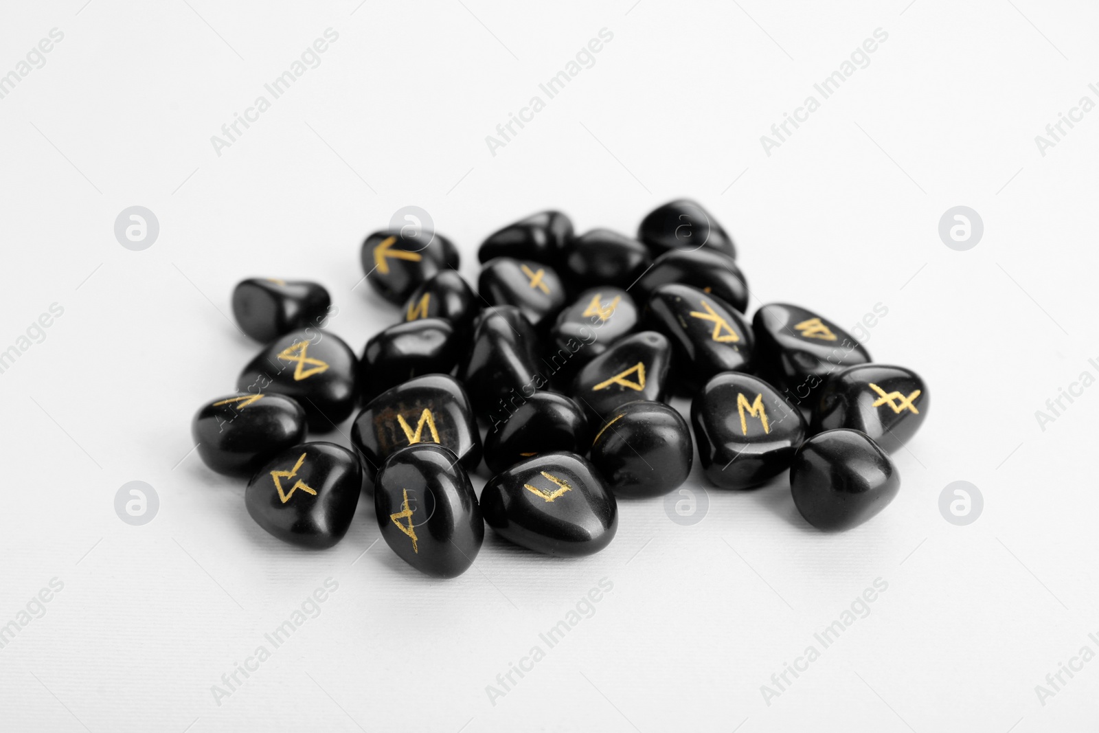 Photo of Pile of black rune stones on white background