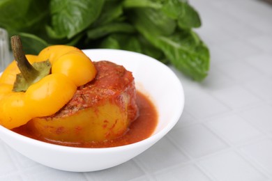 Photo of Delicious stuffed bell pepper on white tiled table. Space for text