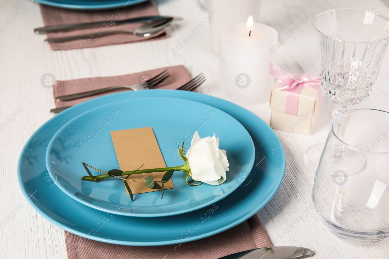 Photo of Elegant festive table setting with blank card on white wooden table