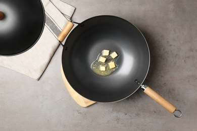Photo of Flat lay composition of frying pan with melting butter on grey table