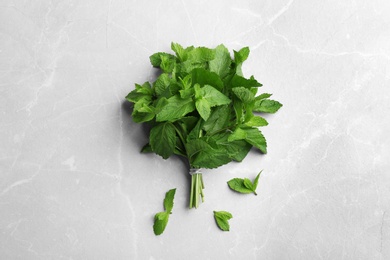 Photo of Bunch of fresh mint on grey marble  background, top view