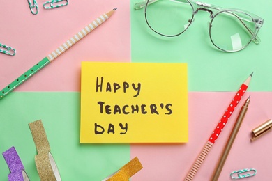 Paper with inscription HAPPY TEACHER'S DAY and stationery on color background