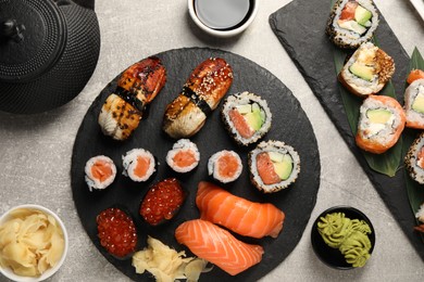 Flat lay composition with delicious sushi rolls on light grey table